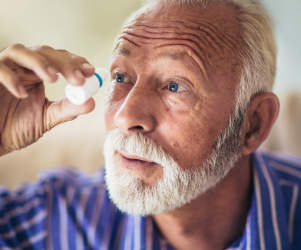 Older man putting in eye drops